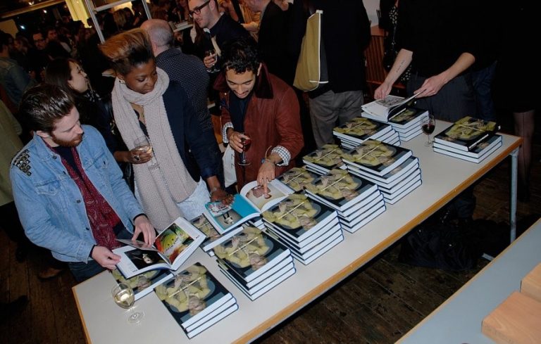 People looking at 100 Years Of Menswear book during the launch event